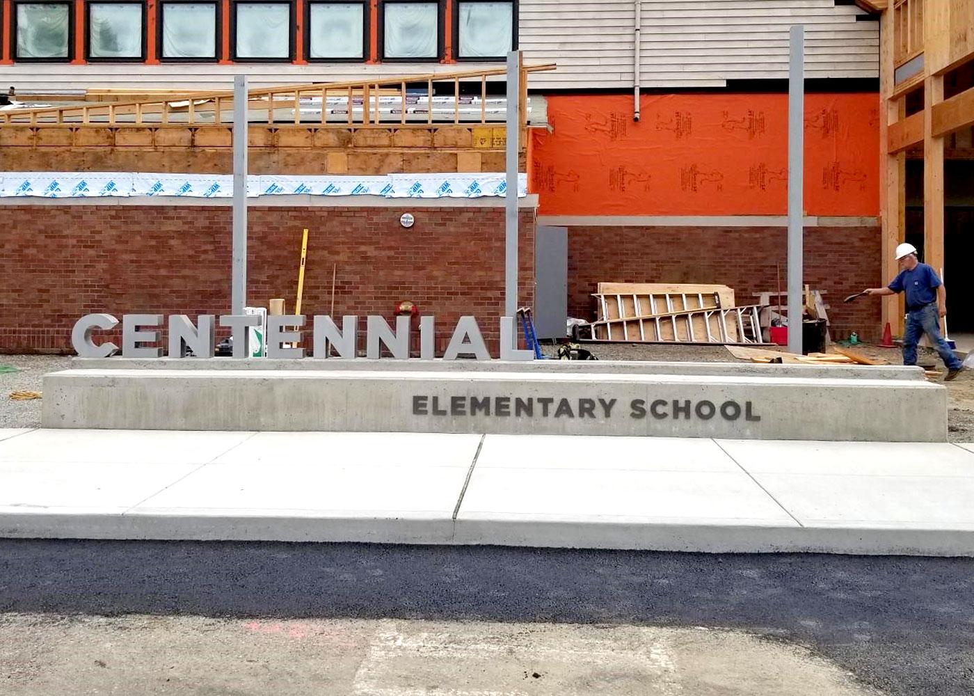 The exterior monument sign for Centennial features dimensional lettering in concrete.