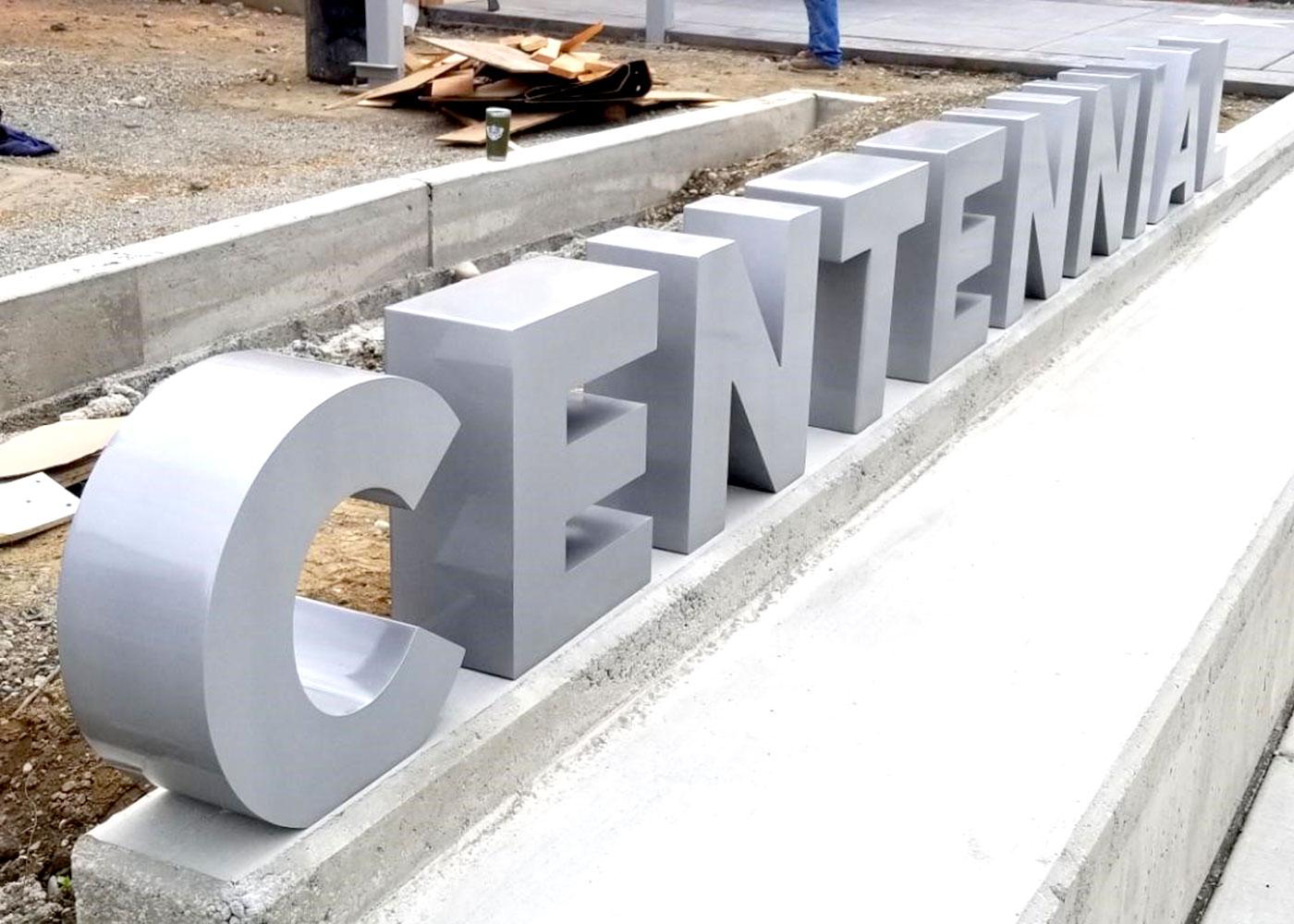 The exterior monument sign for Centennial features dimensional lettering in concrete.